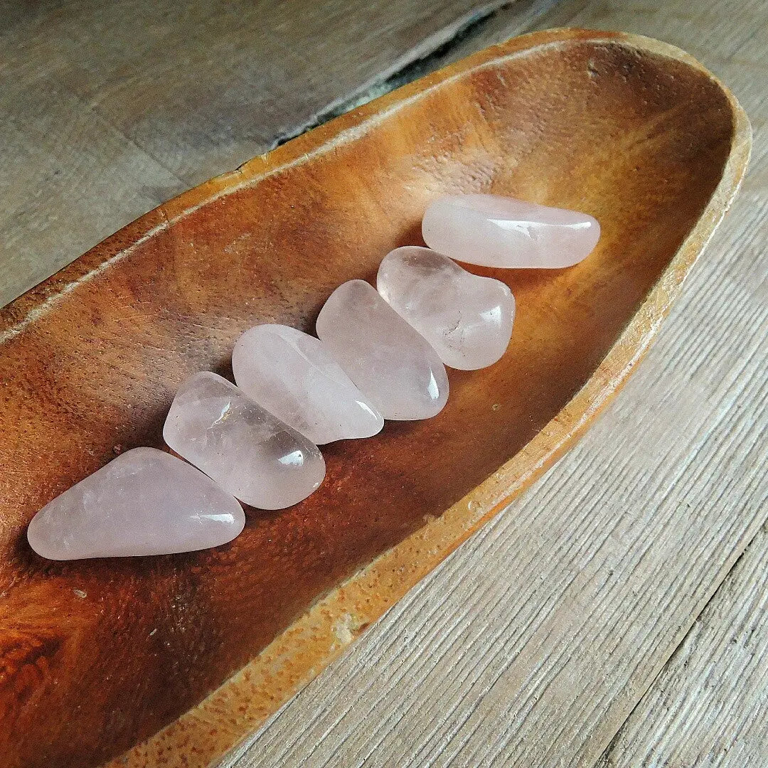Tumbled rose quartz stones showing size range